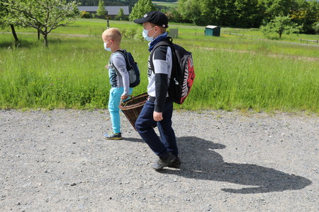 Zwei Jungen tragen einen Sammelkorb